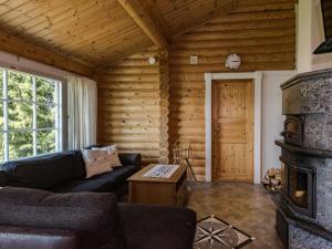 a living room with a couch and a fireplace at Holiday Home Iltarusko by Interhome in Hara