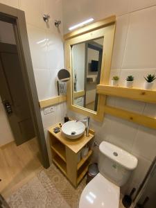 a bathroom with a toilet and a sink and a mirror at Jerez Hostel in Jerez de los Caballeros +36 photos