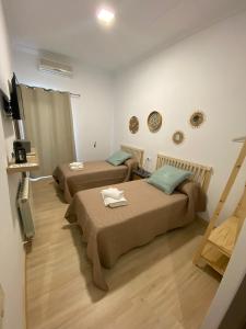 a room with two beds and a flat screen tv at Jerez Hostel in Jerez de los Caballeros