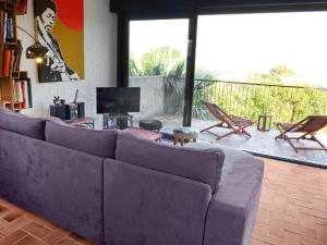 サン・テギュルフにあるVilla La Maison du Midi by Interhomeのリビングルーム(紫色のソファ、テレビ付)