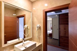 ein Badezimmer mit Waschbecken und Spiegel in der Unterkunft Hotel Lazaro in Podgorica + 94 Fotos