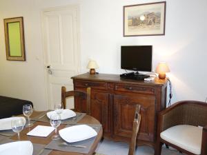 une salle à manger avec une table et une télévision sur une armoire dans l'établissement Studio Les Nautiles by Interhome, à La Madrague