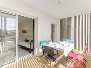 a dining room with a table and colorful chairs at Apartment les Terrasses de Capbreton-1 by Interhome in Capbreton