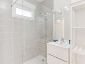 Un baño blanco con ducha y lavabo. en Apartment les Terrasses de Capbreton-1 by Interhome, en Capbreton
