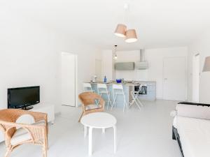 a living room with a couch and a table and chairs at Apartment les Terrasses de Capbreton-1 by Interhome in Capbreton