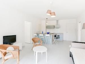 una sala de estar con un sofá, una mesa y sillas en Apartment les Terrasses de Capbreton-1 by Interhome, en Capbreton