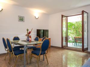 una sala da pranzo con tavolo, sedie e TV di Holiday Home Maravic - MLK161 by Interhome a Dobrinj