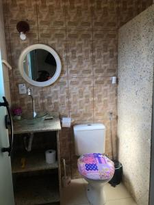 a bathroom with a toilet and a sink and a mirror at Hospedaria Chácara Lumiar in Lumiar