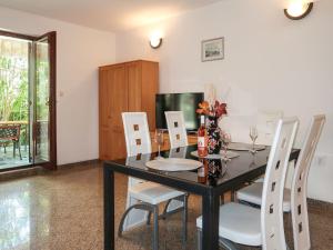 jadalnia z czarnym stołem i białymi krzesłami w obiekcie Holiday Home Maravic-1 by Interhome w mieście Dobrinj