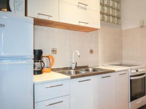 biała kuchnia ze zlewem i lodówką w obiekcie Holiday Home Maravic-1 by Interhome w mieście Dobrinj