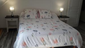 Le Chat Bleu في Pont-Croix: سرير مع بطانيه بيضاء عليها ورد
