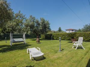 een tuin met twee witte banken en een schommel bij Holiday Home Colli by Interhome in Massa