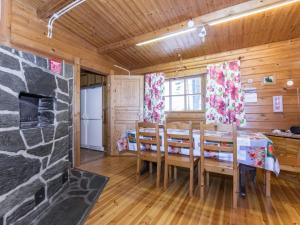 una sala da pranzo con camino in pietra e tavolo e sedie di Holiday Home Kallioranta by Interhome a Keitele