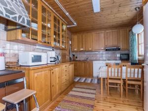 una cucina con armadi in legno, tavolo e sedie di Holiday Home Kallioranta by Interhome a Keitele