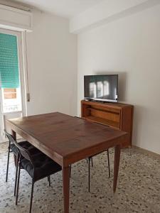 uma mesa de madeira num quarto com uma televisão numa secretária em Casa Vacanza Gabriella em Montesilvano