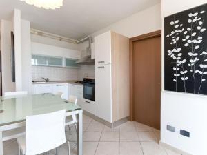 a kitchen with a glass table and white cabinets at Apartment Comfort-3 by Interhome in San Vincenzo