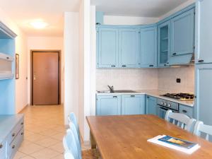 a kitchen with blue cabinets and a wooden table at Apartment Santa Costanza-3 by Interhome in San Vincenzo +20 photos