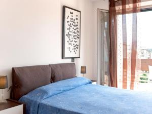 a bedroom with a bed with blue sheets and a window at Apartment Santa Costanza-3 by Interhome in San Vincenzo