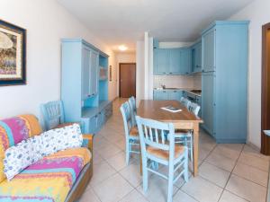 a kitchen with blue cabinets and a table and chairs at Apartment Santa Costanza-3 by Interhome in San Vincenzo +16 photos
