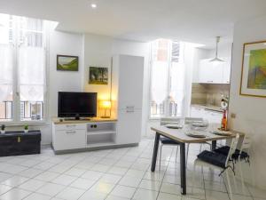 a living room with a table and a tv and a kitchen at Apartment Vieux Nice by Interhome in Nice