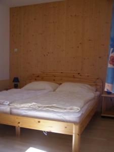 Cama de madera en habitación con pared de madera en Haus im Turm, en Bad Kleinkirchheim