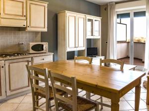 Una cocina con una mesa y sillas de madera. en Apartment Santa Costanza-4 by Interhome, en San Vincenzo