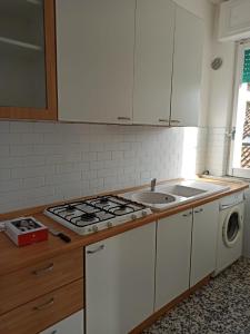 a kitchen with a stove top oven next to a sink at Casa Vacanza Gabriella in Montesilvano