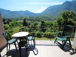 Un balcón con sillas y una mesa con vista a las montañas. en Apartment La Rocca by Interhome, en Porto Valtravaglia