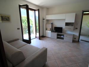 Una sala de estar con un sofá y un televisor. en Apartment La Rocca by Interhome, en Porto Valtravaglia