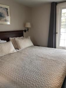 a bedroom with a large white bed with a window at My Friends Inn Manitoulin in Manitowaning