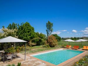 a swimming pool with chairs and umbrellas in a yard at Holiday Home Le Nuvole by Interhome in Pucciarelli