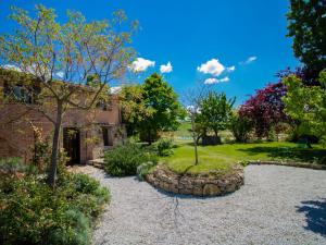 a garden in front of a brick house at Holiday Home Le Nuvole by Interhome in Pucciarelli