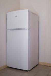 einen weißen Kühlschrank in einem Zimmer mit einer Wand in der Unterkunft Aroma Studios in Lakíthra
