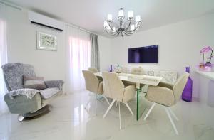 ein weißes Esszimmer mit einem Tisch und Stühlen in der Unterkunft Casa Aurelia - Aurelia Design in Krk