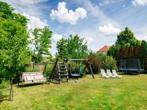 a swing set and two chairs in a yard at Holiday Home Villa Mediterran by Interhome in Balatonszemes