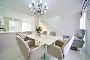 ein Esszimmer mit einem weißen Tisch und Stühlen in der Unterkunft Casa Aurelia - Aurelia Design in Krk