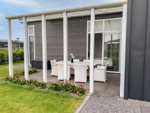 un patio con una mesa blanca y sillas blancas en Holiday Home Vakantiehuis Ruisweg 97 by Interhome en Wemeldinge