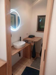 ein Badezimmer mit einem weißen Waschbecken und einem Spiegel in der Unterkunft Tiny House FAMILY Ruheoase in Zwettl Stadt