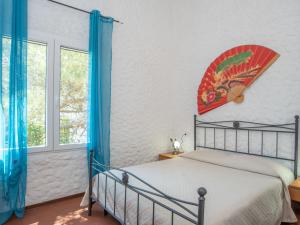 Schlafzimmer mit einem Bett mit blauen Vorhängen in der Unterkunft Apartment Villa Stefania by Interhome in Valledoria