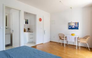 a bedroom with a table and chairs in a room at Apartments Silvija in Mokošica