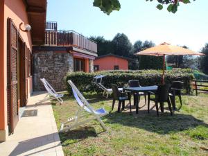 a patio with a table and chairs and an umbrella at Holiday Home Residenza Agrifoglio-11 by Interhome in Luino