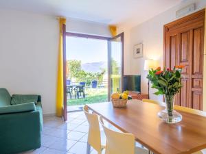 a dining room with a table with a vase of flowers at Holiday Home Residenza Agrifoglio-11 by Interhome in Luino