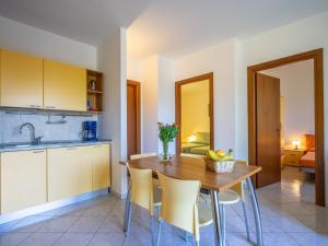 a kitchen and dining room with a wooden table and chairs at Holiday Home Residenza Agrifoglio-11 by Interhome in Luino +29 photos