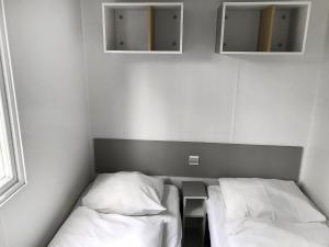 a small room with two beds and two mirrors at Holiday Home De Brenkberg-1 in Schinveld
