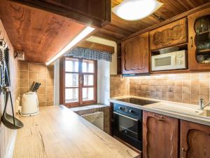 a kitchen with wooden cabinets and a counter top at Holiday Home Lánov by Interhome in Horní Lánov