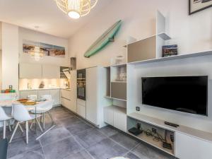 a kitchen with a large television and a table and chairs at Apartment Domaine Aïga-1 by Interhome in Soorts-Hossegor