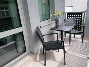 a balcony with a table and chairs and a vase of flowers at Kempen in Kępno