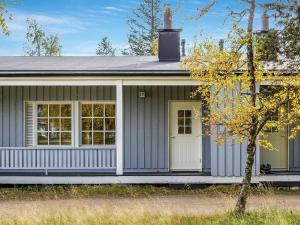 een grijs huis met een witte deur en een boom bij Holiday Home Saariseläntie 8 e 11 by Interhome in Saariselkä