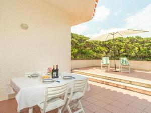 einen Tisch und Stühle auf einer Terrasse mit Sonnenschirm in der Unterkunft Holiday Home Turriga by Interhome in Aglientu