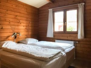 een slaapkamer met 2 bedden en een raam bij Holiday Home De Brenkberg-1 in Schinveld